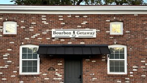 A brick building with a sign reading "Bourbon Getaway" and a black awning over the entrance. - Springside Bourbon Getaway (Georgetown)