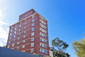 A multi-story brick building with a flat roof and multiple windows. - Harbour Views from North Sydney High Street (North Sydney)