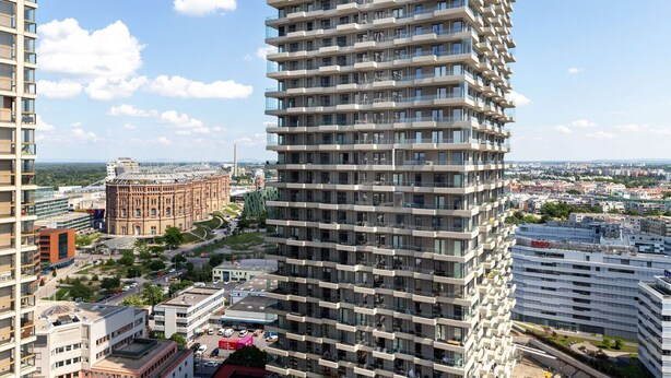 A high-rise building with multiple balconies, surrounded by other buildings and a clear sky. - Fresh Landstraße 1BR w/ Pool, Gym & Cellar, nr Hyblerpark, by Blueground (Vienna)