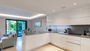 Una cocina moderna con armarios blancos, una isla integrada y un amplio ventanal con vistas al exterior.