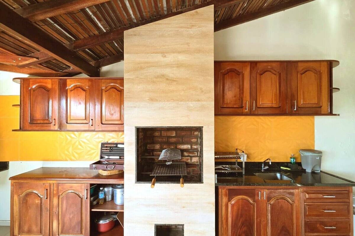 Une cuisine avec des meubles en bois, un four en briques intégré et un évier.