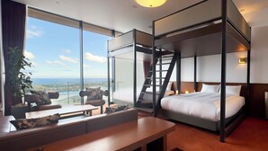 Ein modernes Hotelzimmer mit einem großen Bett, einem Schreibtisch und Meerblick.