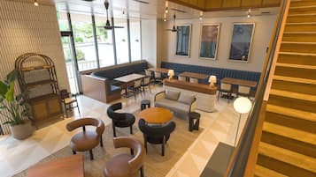A modern interior with seating areas, tables, and a staircase.