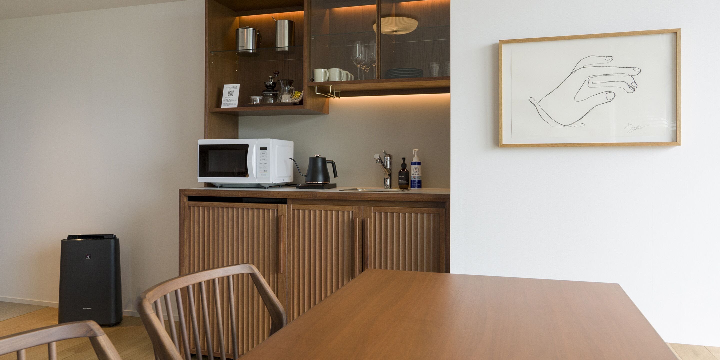 Una cucina moderna con forno a microonde, macchina del caffè e un quadro appeso al muro.