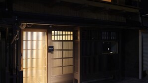 Ein Gebäude mit traditionellem japanischen Eingang, bestehend aus Schiebetüren und einem kleinen Fenster.