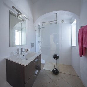 Une salle de bain moderne avec un meuble-lavabo, une douche et des toilettes.