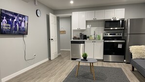Een moderne keuken met witte kasten, roestvrijstalen apparatuur en een grijze vloerkleed.