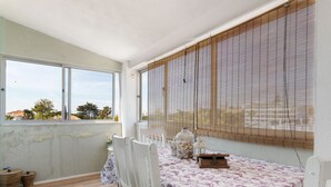 Una habitación con una mesa, sillas, un ventanal y vistas al exterior.