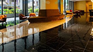 A modern lobby with a curved ceiling, a reception desk, seating area, and large windows offering a view of the outside. - The Axon Bukit Bintang by SMOVF BNB (Kuala Lumpur)