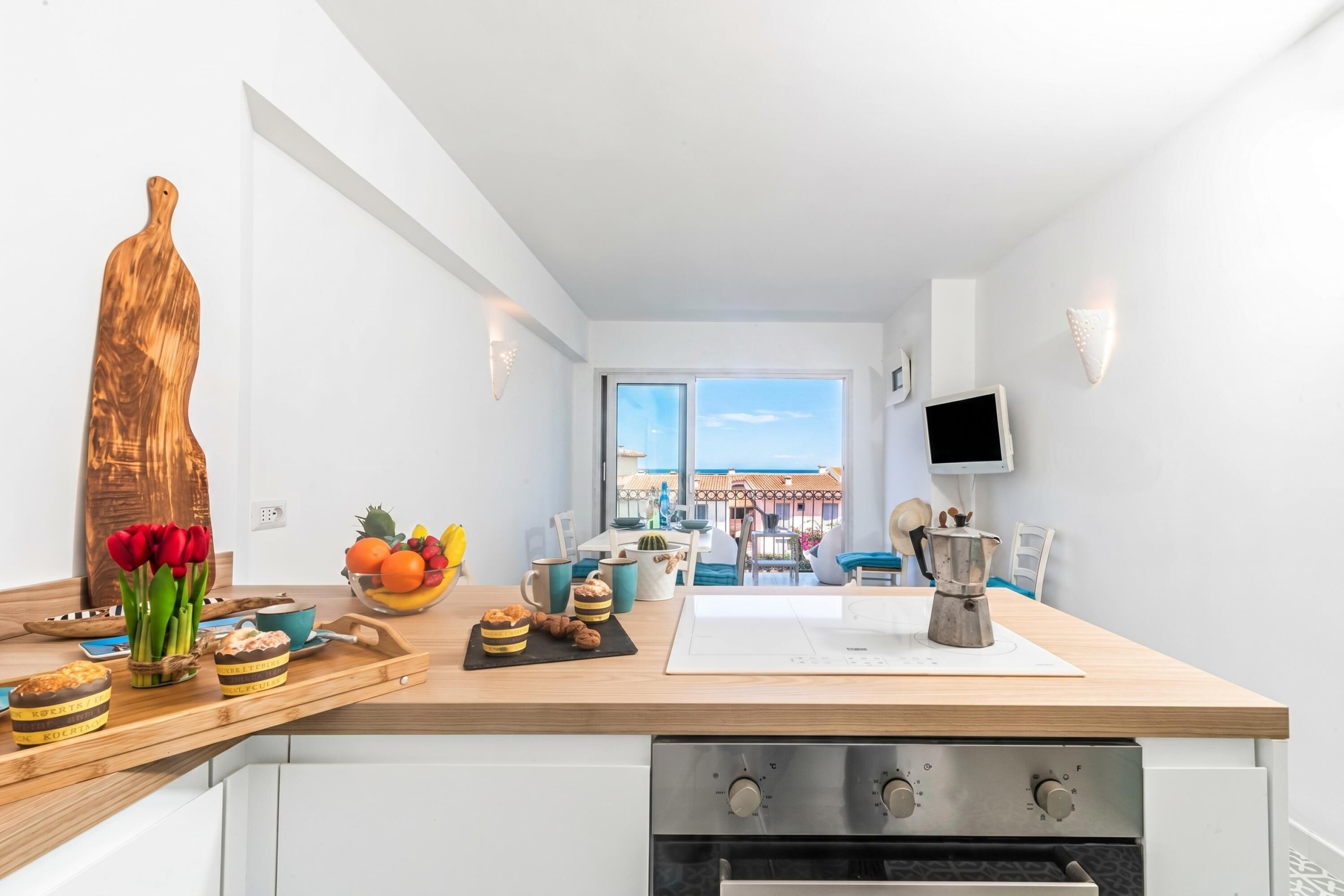 Eine moderne Küche mit einer Holzausziehtheke, einem großen Fenster und Blick ins Freie.
