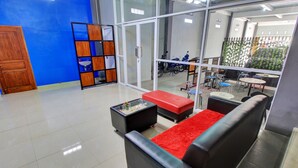 A modern lobby with a glass partition, a red carpeted area, and a seating arrangement. - Hotel O Gm Guest House (Wonogiri)