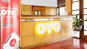 A reception desk with the OYO logo, a red advertisement for OYO Hotels, and a sign for Hotel Dewi Sri. - Super OYO 759 Hotel Dewi Sri (Yogyakarta)