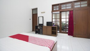 A bedroom with a bed, a desk, a computer, and a wardrobe. - Super OYO 759 Hotel Dewi Sri (Yogyakarta)