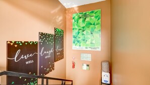 A hallway with a geometric wall art, a fire extinguisher, and a water dispenser.