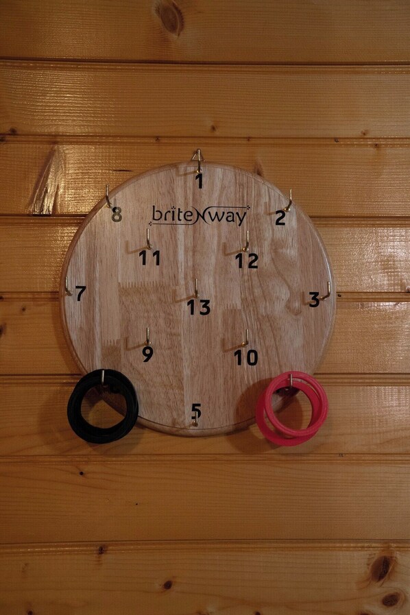 A wooden wall clock with numbers and the brand 'briteway' on it, mounted on a wooden wall.