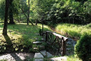A natural outdoor area with a wooden bridge, stone steps, and a lamp post. - Babblebrook Lodge Creekfront Cabin w/River Access Close to Town (Murphy)