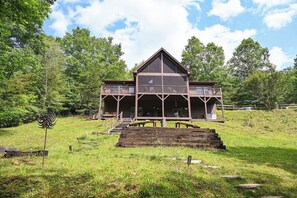 A large wooden building with a balcony, surrounded by a grassy area and trees. - Babblebrook Lodge Creekfront Cabin w/River Access Close to Town (Murphy)