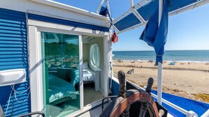 A boat with a glass door leading to a room with a bed and a window. - Rio Del Mar Boathouse - steps from the beach (Aptos)
