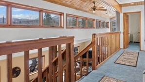 Una escalera de madera con vistas al exterior a través de amplios ventanales.