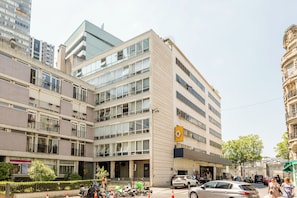 A multi-story hotel with a modern facade, large windows, and a prominent yellow sign.