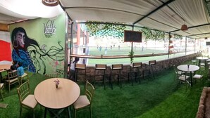 An indoor area with a green artificial turf, a brick wall, and a bar area with a red counter. - valle verde (Urubamba)