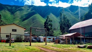 A rural setting with a sign reading "Bienvenidos" and a building with a corrugated metal roof. - valle verde (Urubamba)