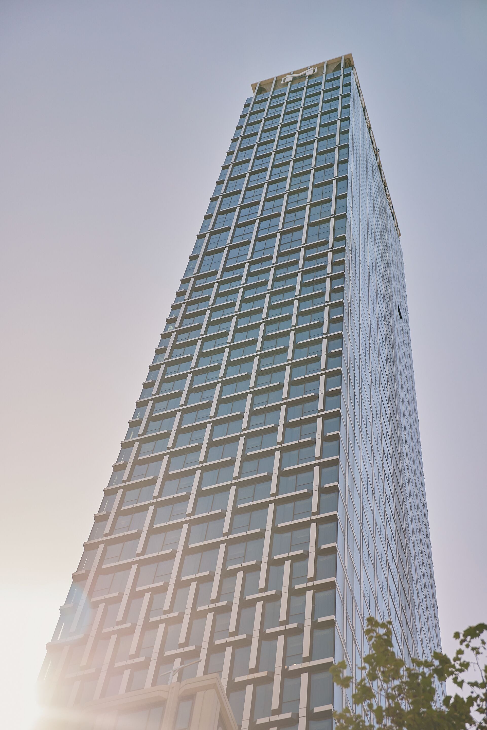 A tall, modern skyscraper with a grid-like facade and numerous windows.