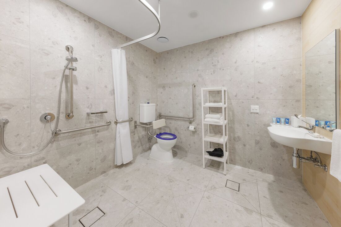 A modern bathroom with a shower, toilet, and sink.