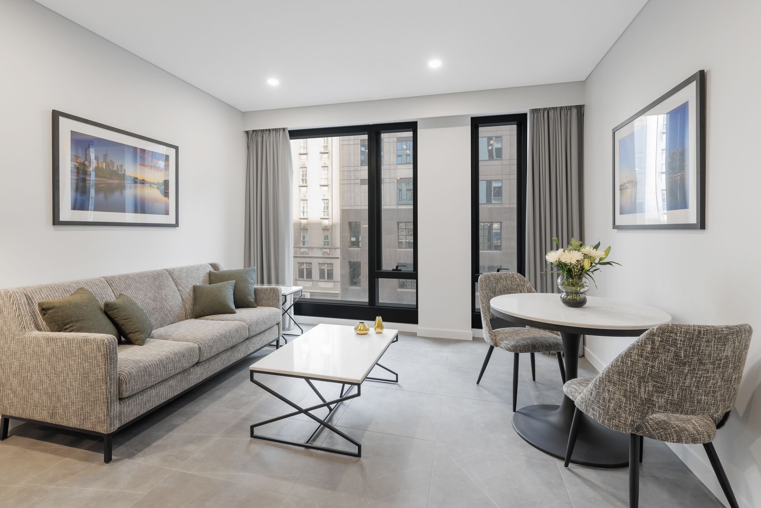 A modern living room with a sofa, a coffee table, and a round table with chairs.