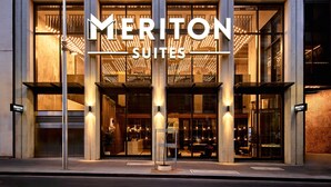 A hotel entrance with a prominent sign reading "MERITON SUITES".