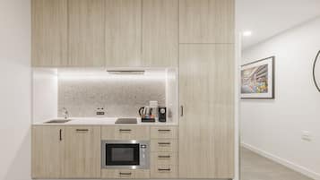 A modern kitchen with built-in appliances, a countertop, and a wall-mounted artwork.