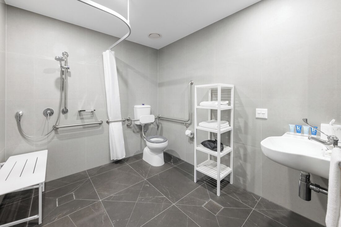 A modern bathroom with a shower, toilet, and sink.