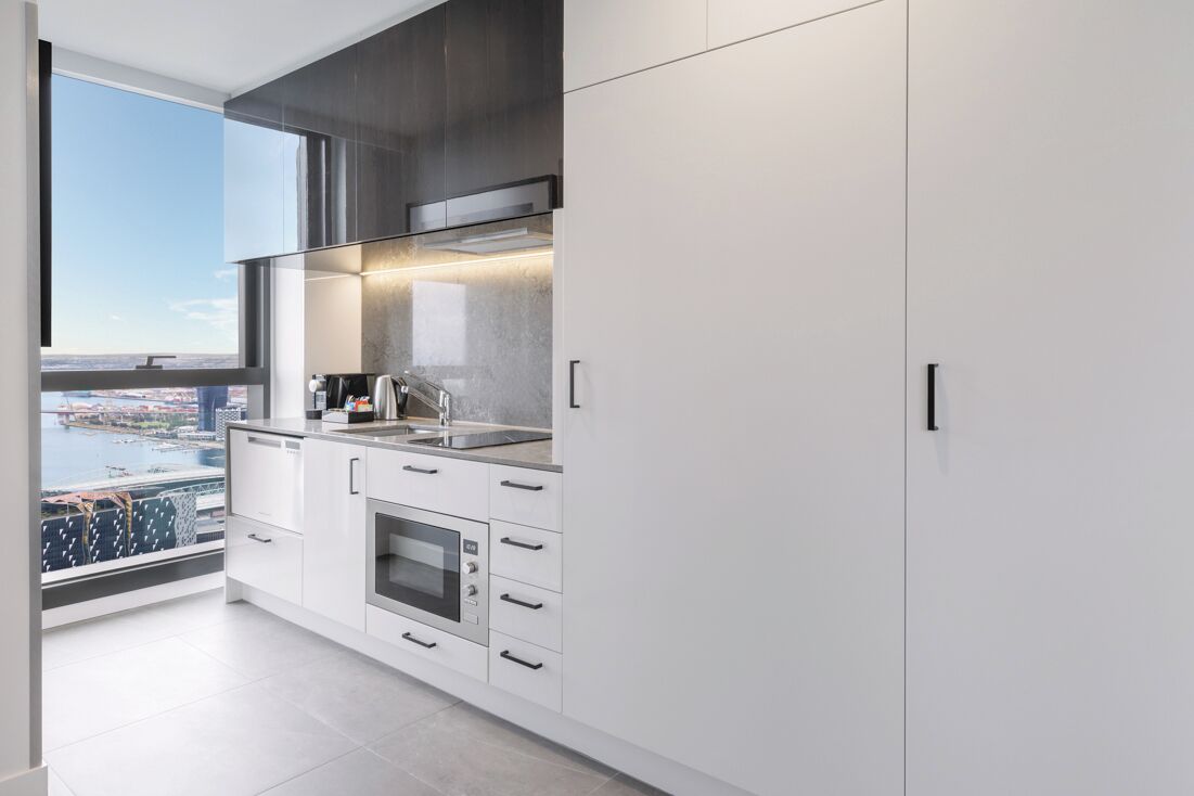 Una cocina moderna con un ventanal grande, horno integrado y vistas a la ciudad.