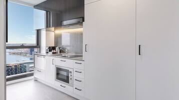 Una cocina moderna con un ventanal grande, horno integrado y vistas a la ciudad.