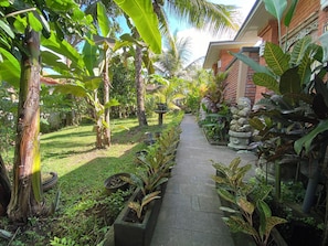 Stroll through the lush garden, lined with a variety of plants and neatly arranged planters, to the traditional building with a brick facade.