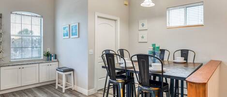 A dining area with a wooden table, black chairs, and a white door.