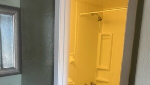 Een badkamer met toilet, bad en douche.