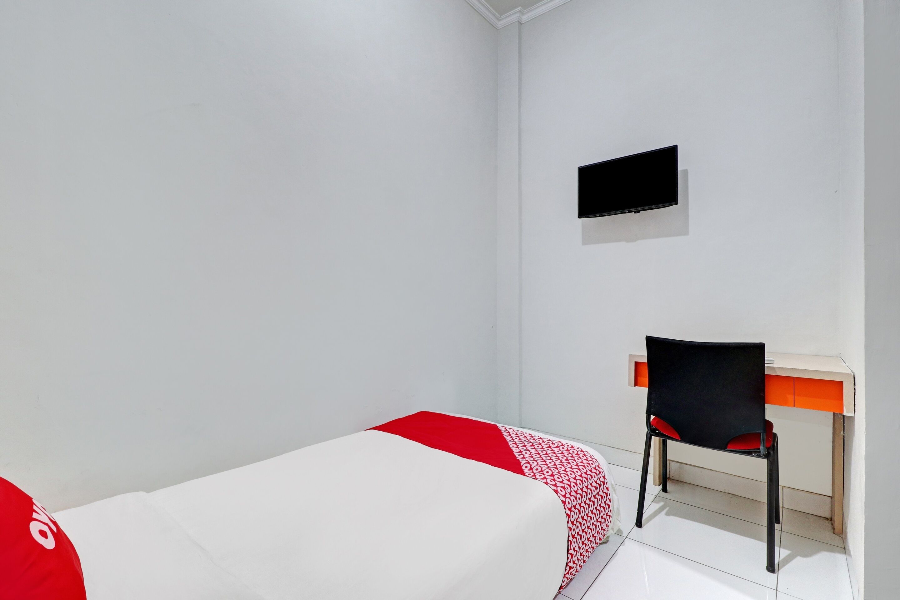Ein kleines, sauberes Zimmer mit einem Einzelbett, einem Schreibtisch und einem Stuhl.