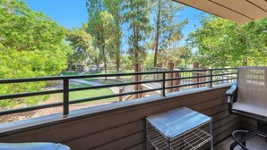 A balcony with a view of a park, a metal grill, and a chair. - Fantastic Location! Heated Pool, Close to Giants Stadium, Minutes from Old Town Scottsdale + Golfing (Scottsdale)