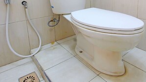 A bathroom with a toilet, a shower, and a drain. - OYO 91777 Kemuning Guesthouse (Sempe)