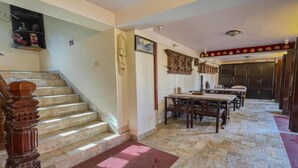 A staircase leading to a dining area with a wooden table and chairs. - MeroStay 222 Guest House DD (Bhaktapur)