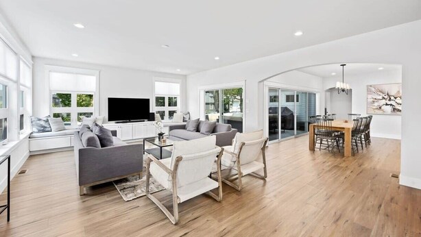 Un salon spacieux comprenant un canapé, des fauteuils, une table basse et un téléviseur.