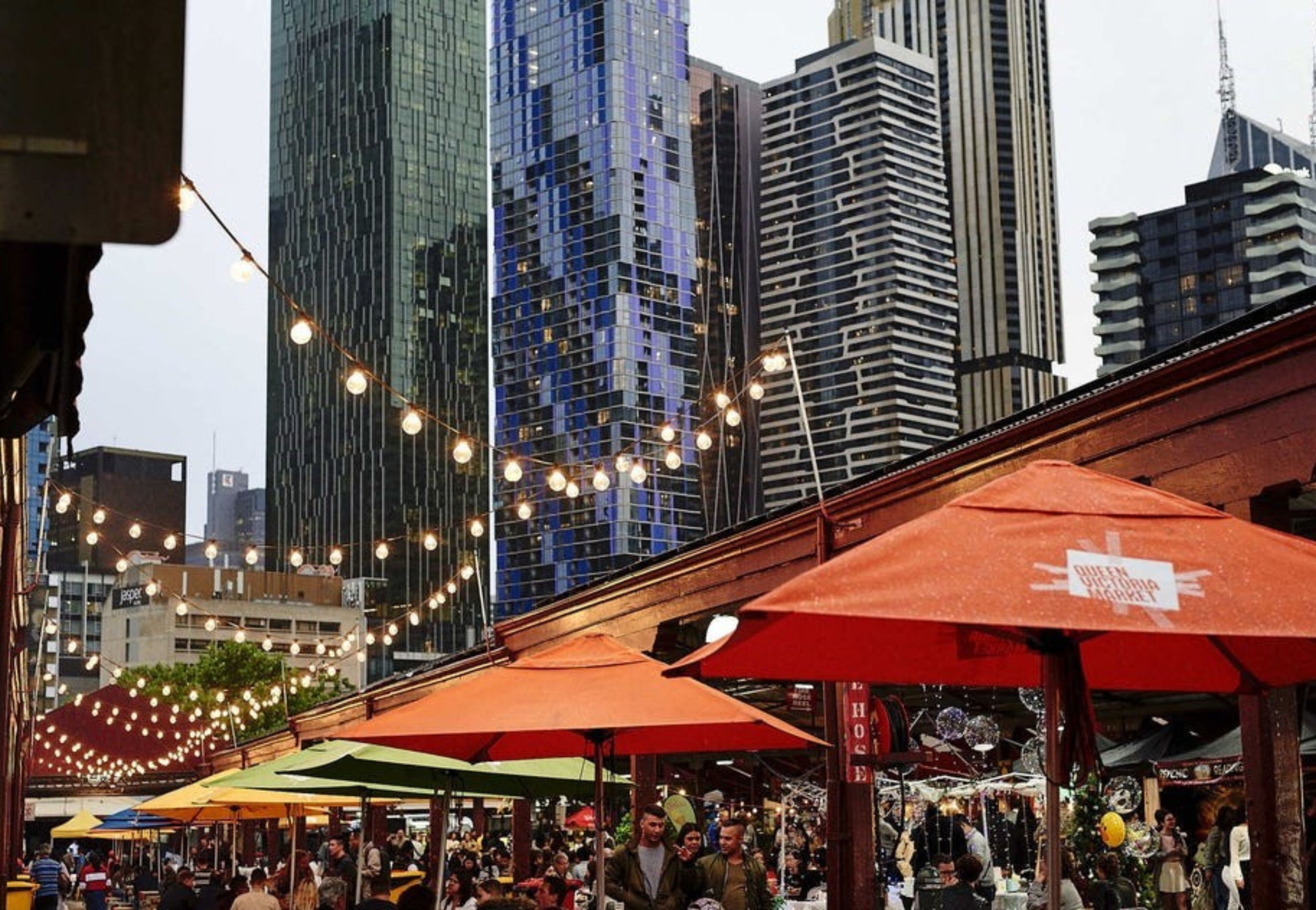 A bustling outdoor market with various stalls and people.