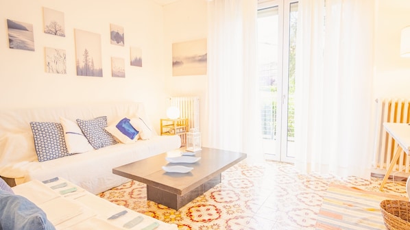 A bright room with a sofa, a coffee table, and a patterned floor.