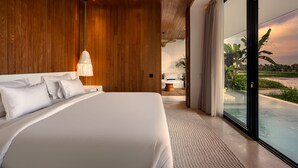 A modern bedroom with a large bed, wooden panel walls, a view of a swimming pool, and a bathroom in the background. - Charming 1BR Villa w/ Pool | Green Flow Ubud (Ubud)