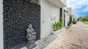 A modern building with a stone wall, a statue, and a sign reading 'Villa 09'. - Charming 1BR Villa w/ Pool | Green Flow Ubud (Ubud)