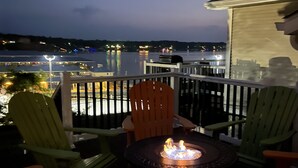 A balcony with outdoor seating and a fire pit.