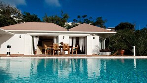 Une maison à deux étages avec une piscine à l’avant.