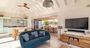A modern living room with a sofa, TV, and wooden furniture.