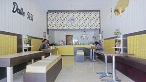 A restaurant interior with a modern design, featuring a counter, seating area, and decorative wall patterns.